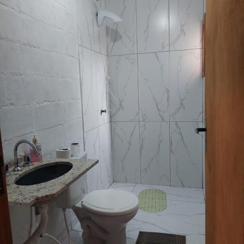 a bathroom with a shower and a toilet and a sink at Casa para temporada em Arroio do Silva a 900m do mar in Arroio do Silva