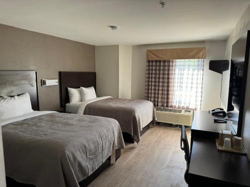 a hotel room with two beds and a television at Quality Inn in Lavonia
