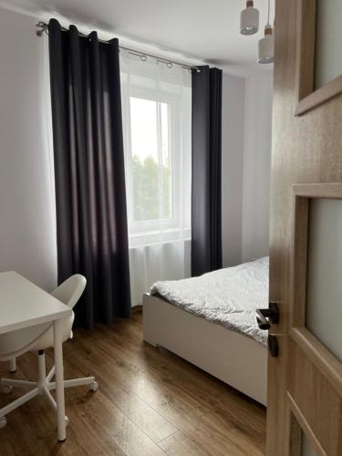 een slaapkamer met een bed en een raam bij Apartament rodzinny 40m2 in Pabianice