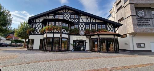 a black and white building with flowers in the windows at Renatas Ferienwohnung Wohnung David in Sasbachwalden