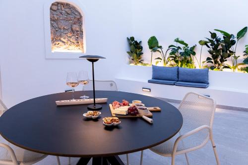 New Villa In Downtown في أثينا: طاولة سوداء مع طبق من الطعام وكؤوس النبيذ