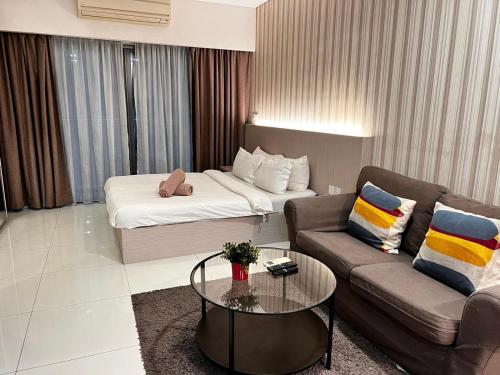 een woonkamer met een bank en een bed bij Mercu Summer Suites KLCC By Minutepointhome in Kuala Lumpur