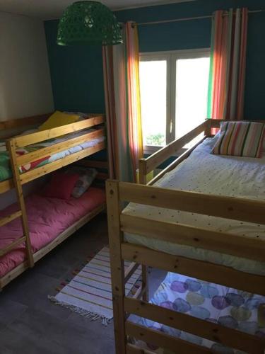 une chambre avec deux lits superposés et une fenêtre dans l'établissement Maison à SOULAC sur Mer avec Jardin, à Soulac-sur-Mer