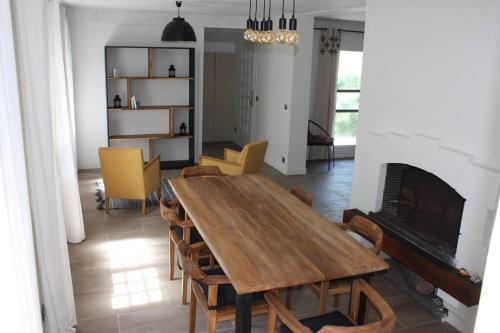 スラック・シュル・メールにあるMaison à SOULAC sur Mer avec Jardinのダイニングルーム(テーブル、椅子、暖炉付)