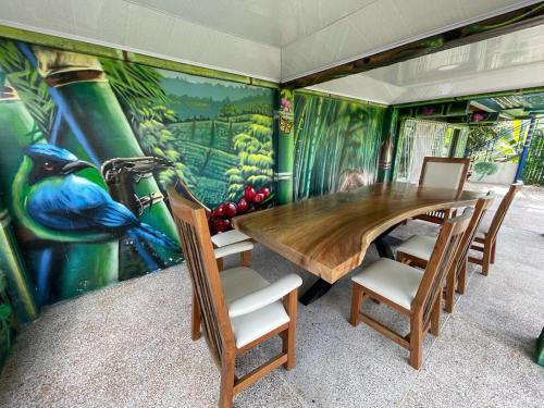 une salle à manger avec une fresque murale représentant un paon dans l'établissement Finca Vista Hermosa, à Santa Rosa de Cabal