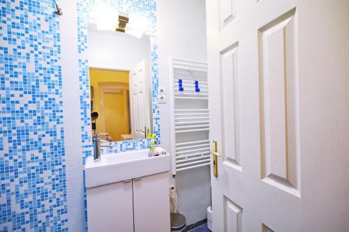 een badkamer met een witte wastafel en een spiegel bij Supreme Astoria Semmelweis in Boedapest