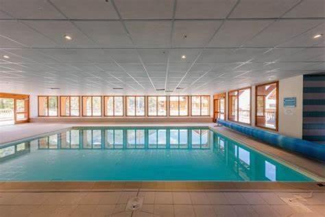 une grande piscine dans un grand bâtiment dans l'établissement Appart. 4 à 6 pers. centre Bois Méan, aux Orres