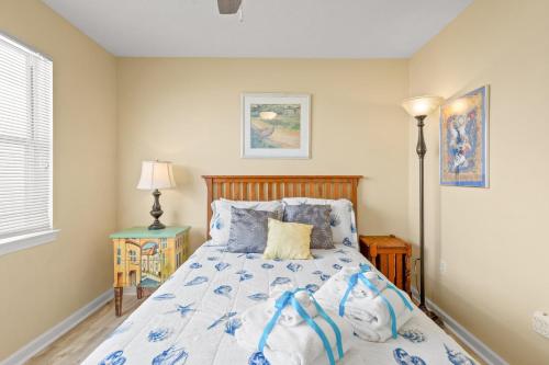 a bedroom with a bed with a blue and white comforter at 21720 Front Beach Rd - Pelican's Nest in Panama City