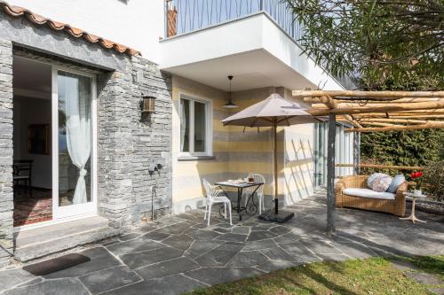 a patio with a table and an umbrella at Villa Ani in Ascona