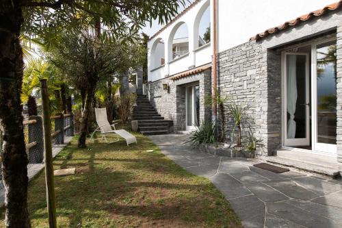 a yard with a chair in front of a house at Villa Ani in Ascona