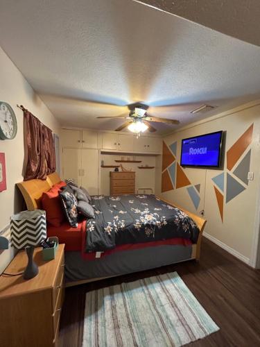 a bedroom with a bed and a tv on the wall at Bonne Nuit Weeki Wachee in Weeki Wachee