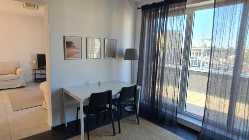 a living room with a table and chairs and a window at Apartament przy centrum in Koszalin