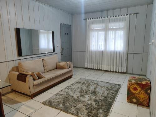 uma sala de estar com um sofá e uma televisão de ecrã plano em Casa para 6 pessoas Oktoberfest em Blumenau
