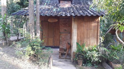 um pequeno edifício de madeira com telhado em ลิ้นฟ้าแคมปิ้งรีสอร์ท em Mae Hong Son