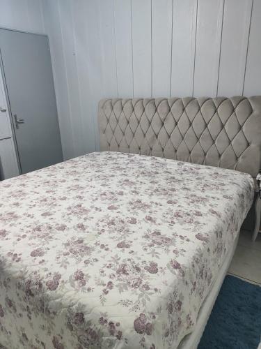 a bed with a floral bedspread on it in a bedroom at Casa para 6 pessoas Oktoberfest in Blumenau