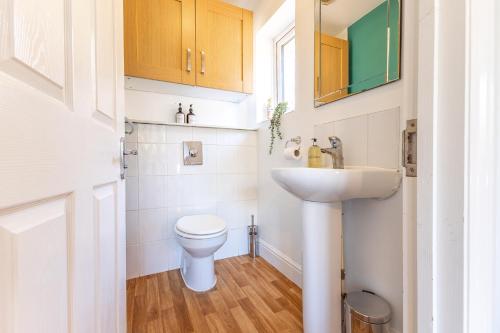 a small bathroom with a toilet and a sink at 5 Bed House Heathrow Egham Virginia Water Sleeps 7 or 8 sharing in Egham