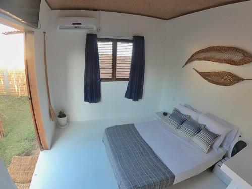 a bedroom with a bed and a window at Casa aloha in Atins