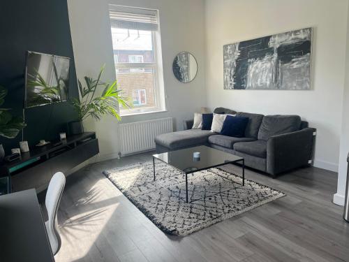 a living room with a couch and a coffee table at Spacious modern 1-bed apartment near Victoria Park & London Stadium in London