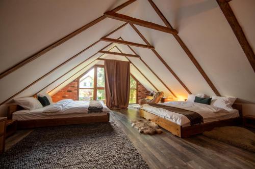 a bedroom with two beds in a attic at La Brazi - by 663A Mountain Chalet in Porumbacu de Sus