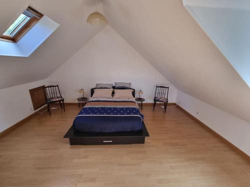 une chambre avec un lit dans un grenier dans l'établissement Maison 8-10 personnes, à Vrocourt