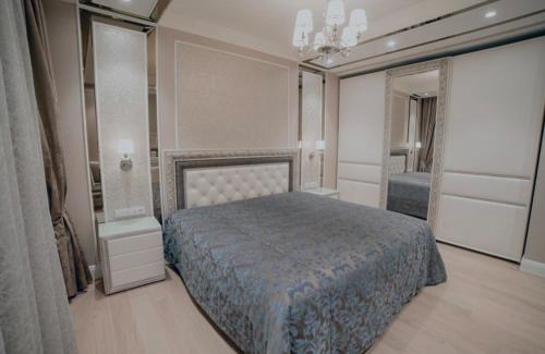 een slaapkamer met een bed en een grote spiegel bij BAI House in Jelgava