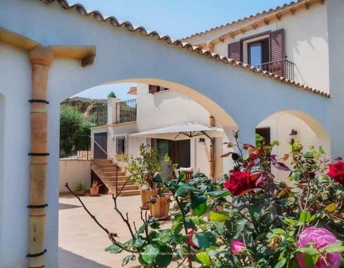 una casa con un paraguas y flores delante de ella en Le 3 Rose apartments, en Montallegro