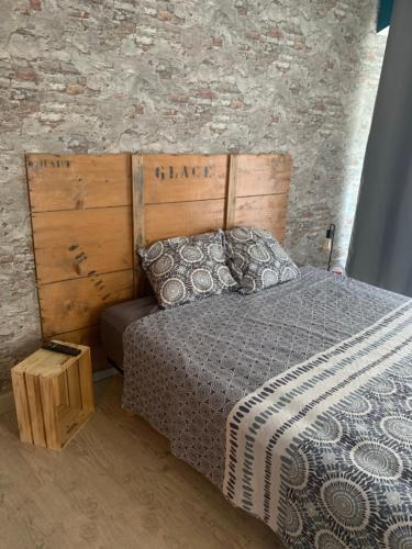 1 dormitorio con cama y pared de ladrillo en Suite parentale 50m2, en Châtillon-Saint-Jean