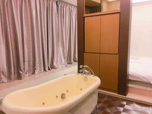 a bath tub in a bathroom with a bed at Park View KLCC ,by DeLive Home in Kuala Lumpur