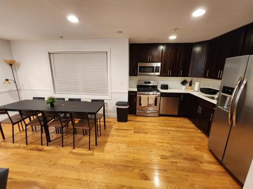 a kitchen with a table with chairs and a refrigerator at Stylish 2BR Apt Mins to NYC! in Union City