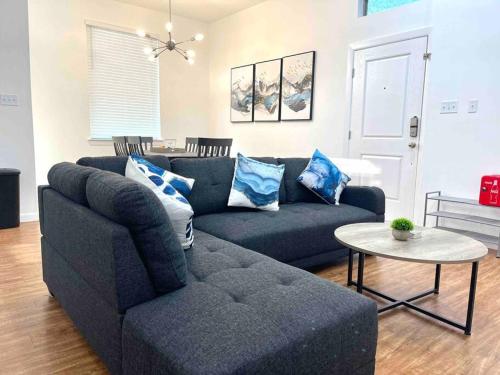 a living room with a blue couch and a table at NEW! 5 min from Mall, Airport, and Dinning! in McAllen