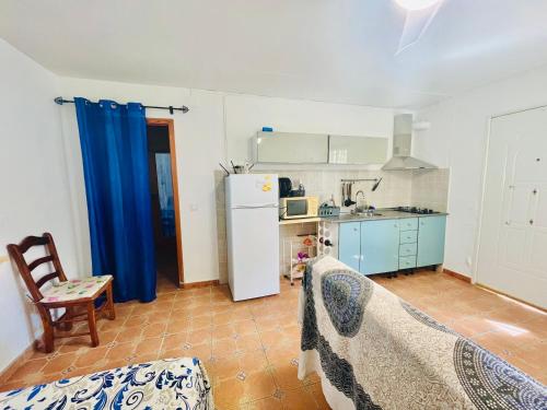 cocina con armarios azules y nevera blanca en Estudio adosado con jardín y parking privado, en Alicante