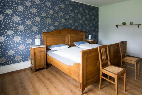 une chambre avec un lit en bois et une chaise dans l'établissement Ferienhaus Wellness-Oase in Lingen Ems , Monteurunterkunft, Wellness exclusive, à Lingen