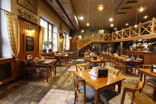 uma sala de jantar com mesas e cadeiras de madeira em AGH Hotel em Rožnov pod Radhoštěm