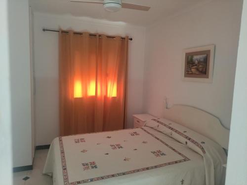 a bedroom with a bed and a curtain at Casa en el centro del pueblo in Conil de la Frontera