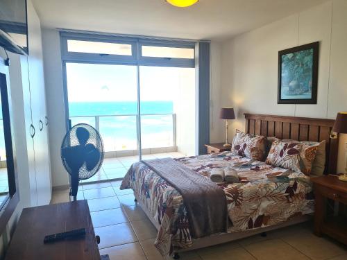 a bedroom with a bed and a large window at Santorini 106A in Margate