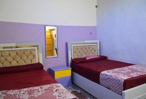 a bedroom with two beds and a mirror at Heissa Hostel in Aswan