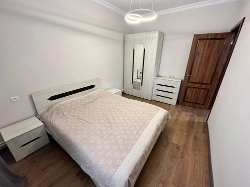 a bedroom with a white bed and a wooden floor at Green Village in Ashtarak