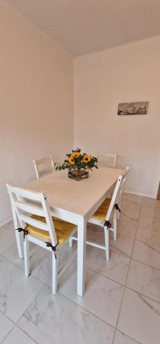 a white table and chairs with a vase of flowers on it at Sweet flat in Tortosa in Tortosa
