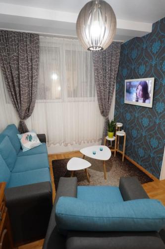 una sala de estar con 2 sofás azules y una mesa. en Stan na dan Paracin 035, en Paraćin