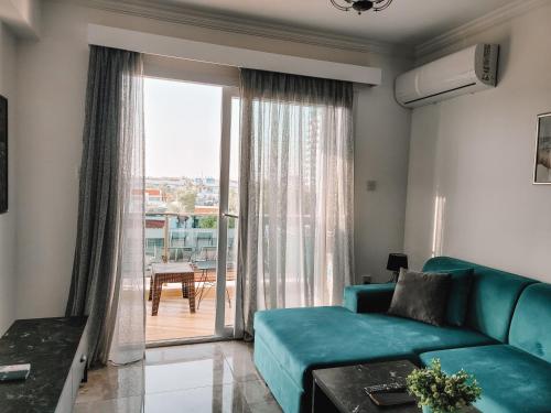 a living room with a couch and a large window at Sea Shell 8 Lovely 2-bedroom Apartment in Saint Yeorgios