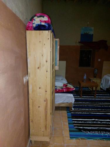 a room with a bed and a wooden door in a room at KASBAH Atlas-Aberdouz in Aït Hattab