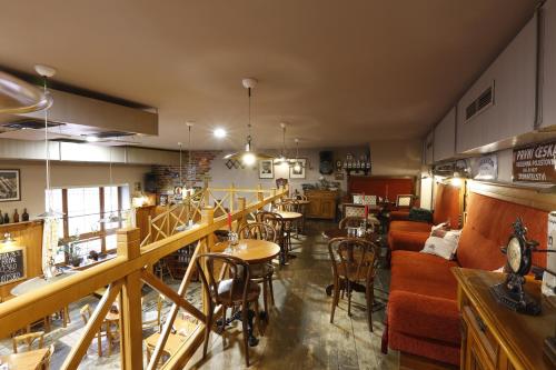 a restaurant with tables and chairs in a room at AGH Hotel in Rožnov pod Radhoštěm