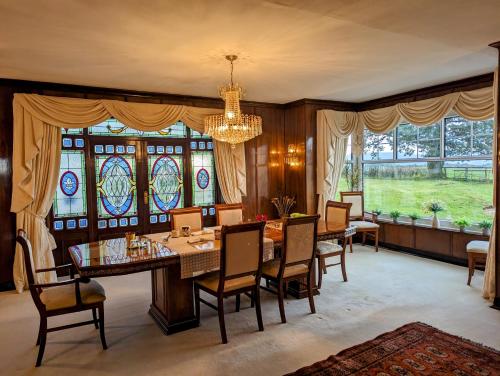 a dining room with a table and chairs and stained glass windows at FINN VILLAGE - Loch Lomond Villa B&B with a Hot Tub in Glasgow