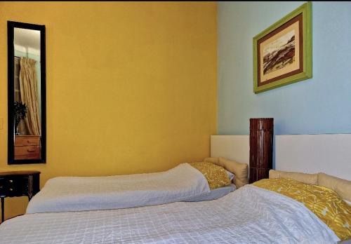 a bedroom with two beds with yellow walls at Home for 2 few steps from casino monte carlo and beach in Beausoleil