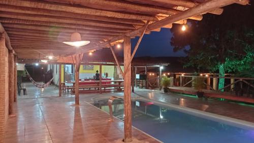a pavilion with a swimming pool at night at Pousada e camping Canastra Mineira in São Roque de Minas
