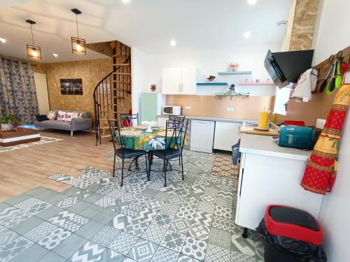 eine Küche und ein Wohnzimmer mit einem Tisch und Stühlen in der Unterkunft La Grange in Toury