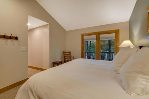 a large white bed in a room with a window at 604 Disciples Village Condo in Boyne Falls