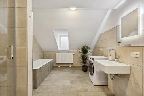 uma casa de banho com um lavatório, uma banheira e um WC. em EasyApartments stilvoll zentral Balkon Hauptbahnhof NETFLIX 130m2 em Hof