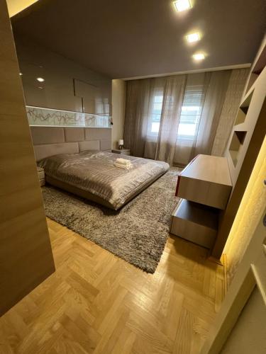 a bedroom with a bed and a table and a window at City Lux Apartman in Nyíregyháza