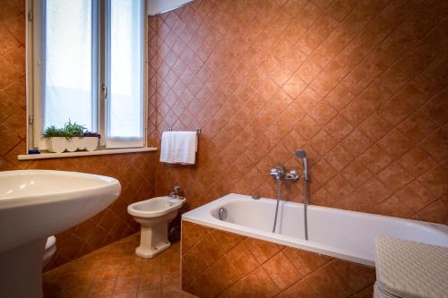 y baño con bañera, aseo y lavamanos. en Villa Cernobbio, en Cernobbio